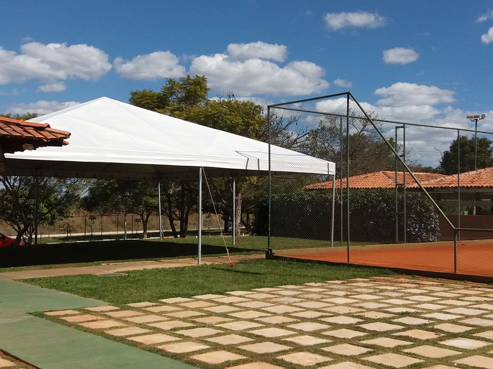 Tenda branca da Mestre Tendas montada ao lado da quadra de tênis de um clube no DF